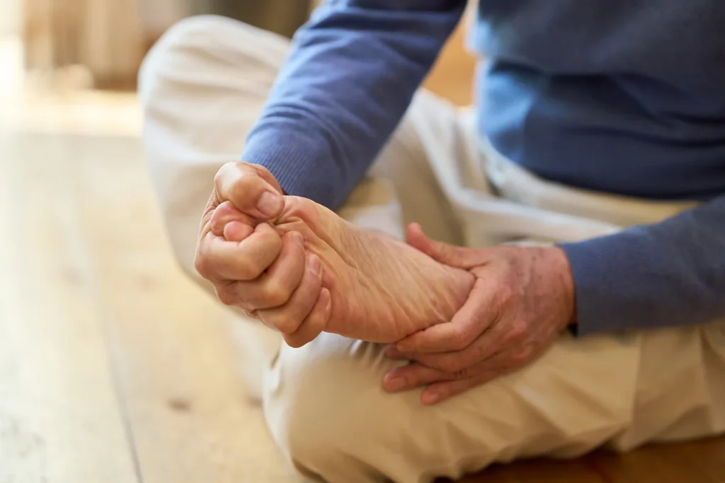 adult massaging foot while sitting