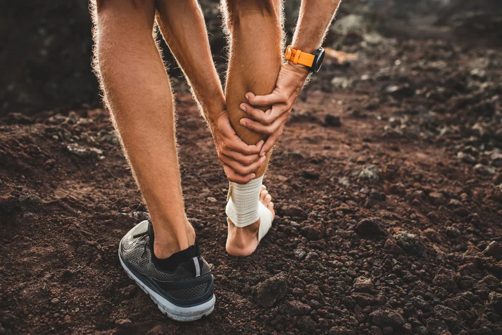 male runner holding injured calf muscle
