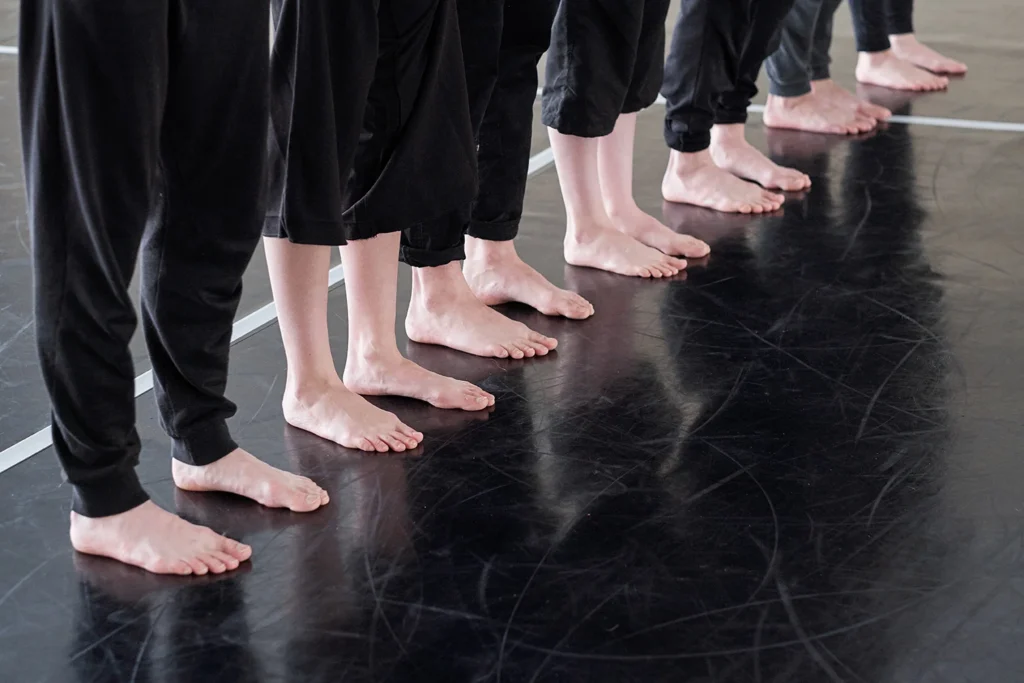 row of legs of barefoot young dancer